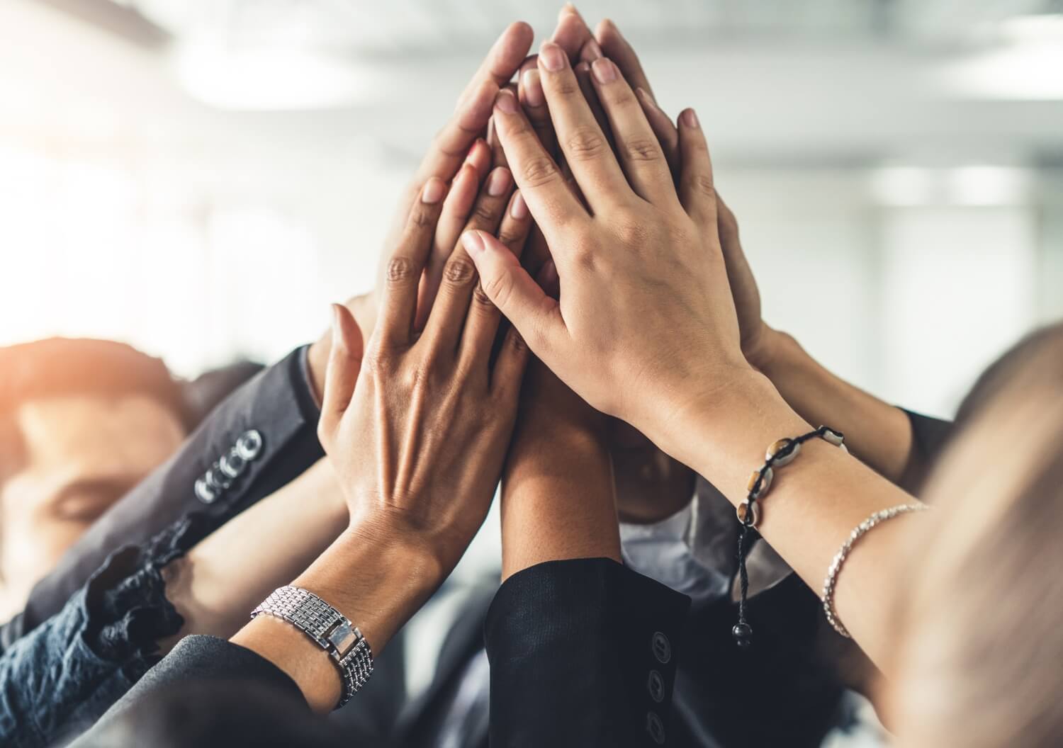 Image of coworkers raising hands together