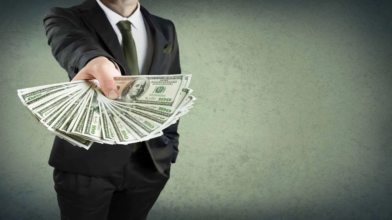 Image of a businessperson fanning out money