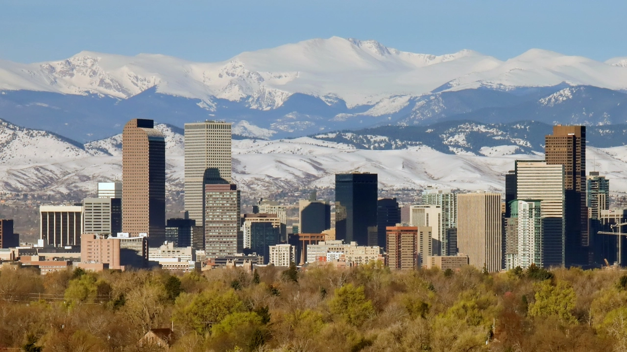 Image of the Denver skyline with snow-capped mountains in the backgroiund